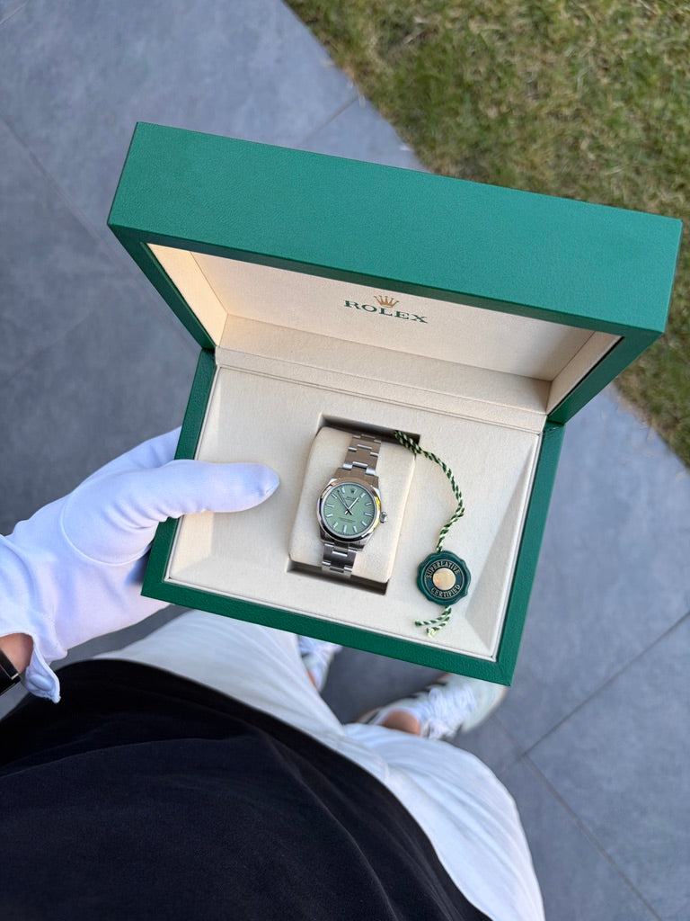 Rolex Oyster Perpetual 31 mm, Referenz 277200, aus Edelstahl mit pistaziengrünem Zifferblatt und Oyster-Armband in einer geöffneten Rolex-Box.